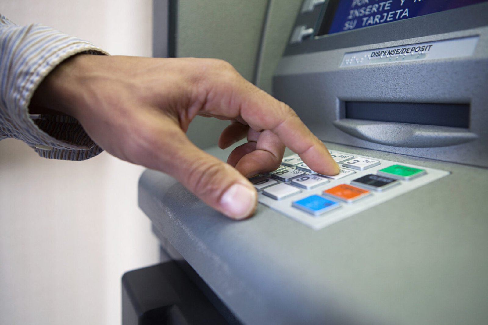 Person using an ATM keypad
