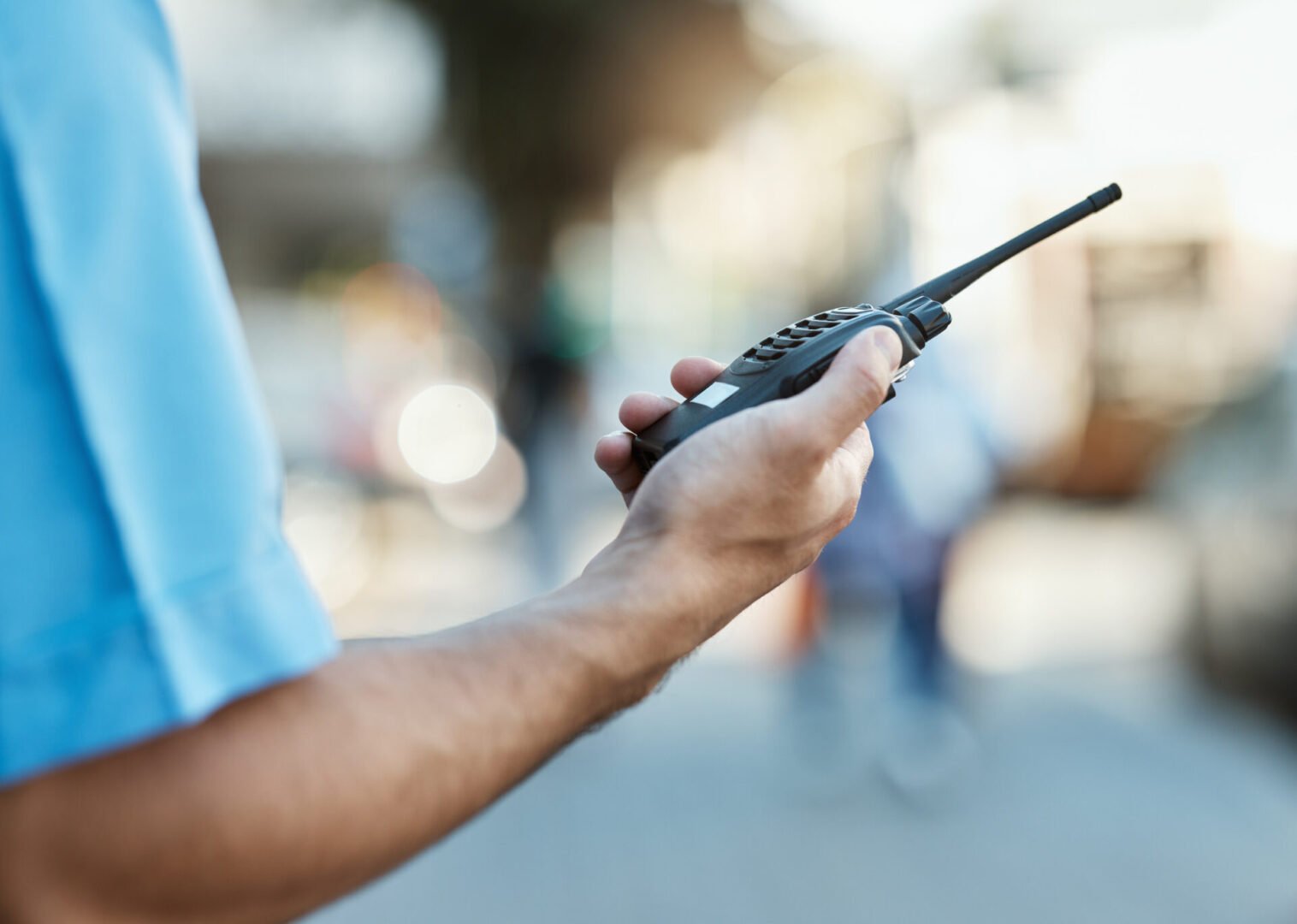 Walkie-talkie in hand, blurred background