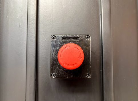 Safety button mounted on metal surface
