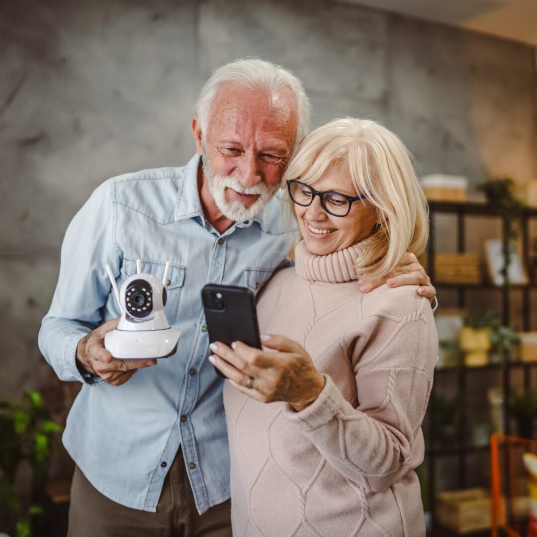 Seniors smiling with home security camera