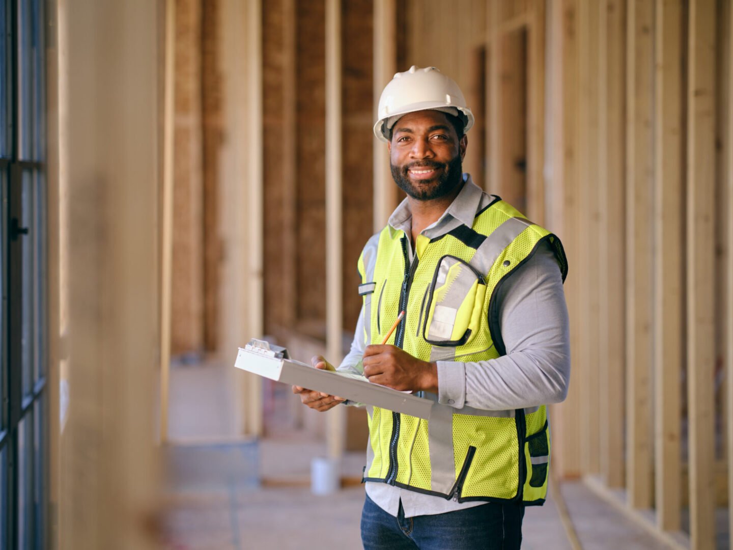 Smiling builder with hard hat indoors