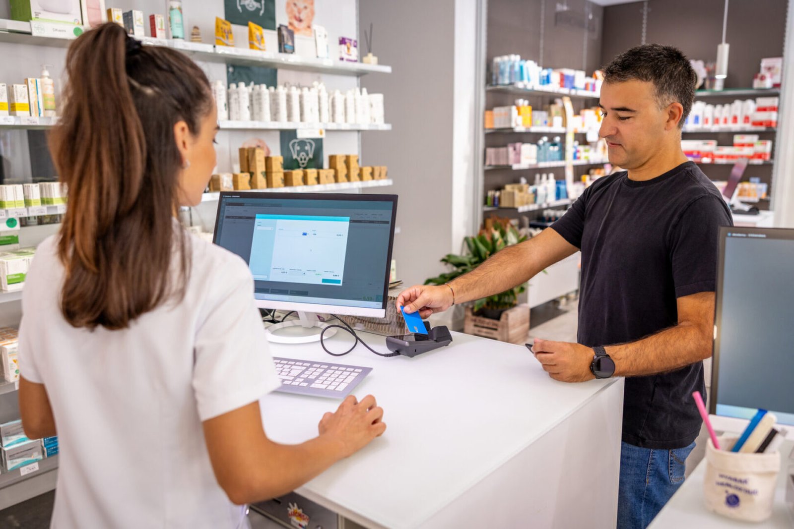 Woman assisting customer in pharmacy