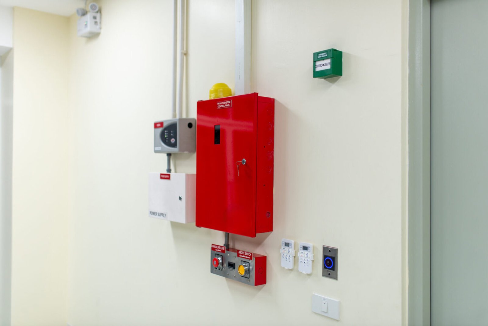 Wall-mounted fire safety equipment including a red fire extinguisher cabinet.